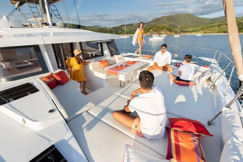 Slide: The Image of People relaxing on a 2021 Bali 4.8 catamaran, enjoying a sunny day on the water. - 32