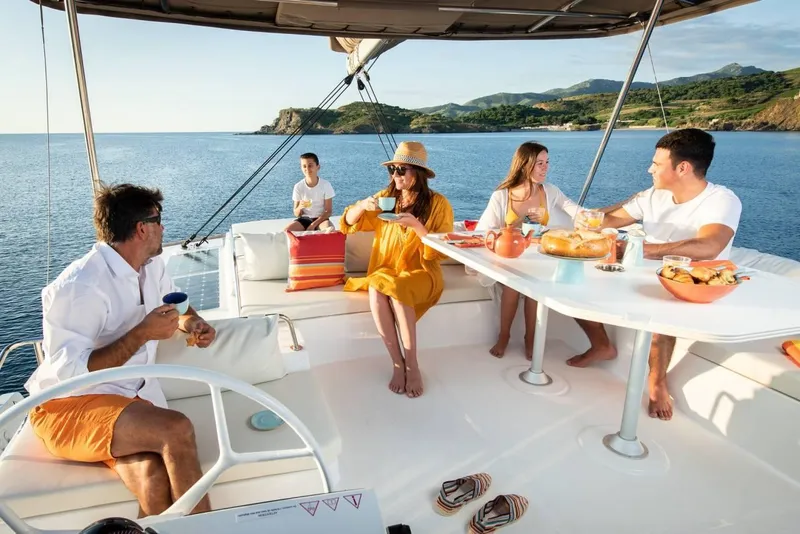 Slide: The Image of People enjoying a meal on a 2021 Bali 4.8 catamaran, with scenic ocean views. - 33