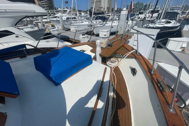 Slide: The Image of 1979 Golden Star Aft Cabin yacht docked at marina with blue covers and wooden deck. - 13