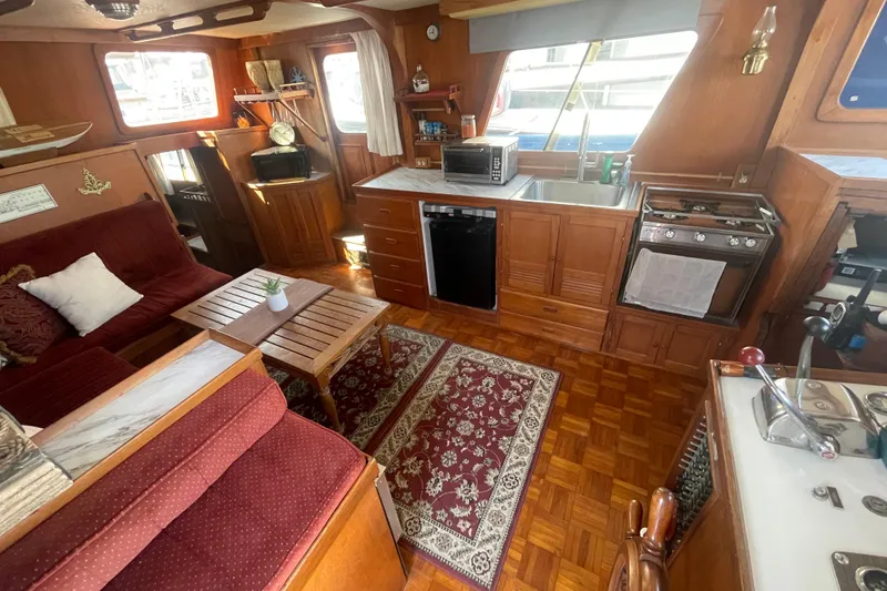 Slide: The Image of Interior of 1979 Golden Star Aft Cabin yacht with cozy seating and kitchen area. - 14