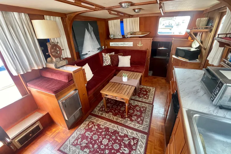 Slide: The Image of 1979 Golden Star Aft Cabin interior with vintage decor, red seating, and nautical accents. - 15