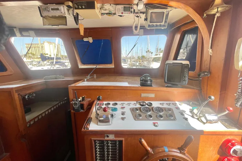 Slide: The Image of 1979 Golden Star Aft Cabin yacht interior with navigation controls and wooden steering wheel. - 18