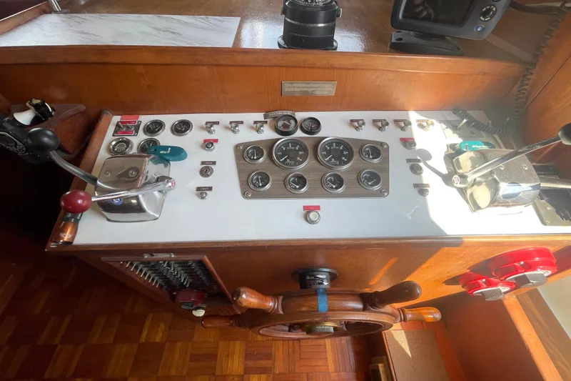 Slide: The Image of 1979 Golden Star Aft Cabin boat control panel with gauges and steering wheel. - 19