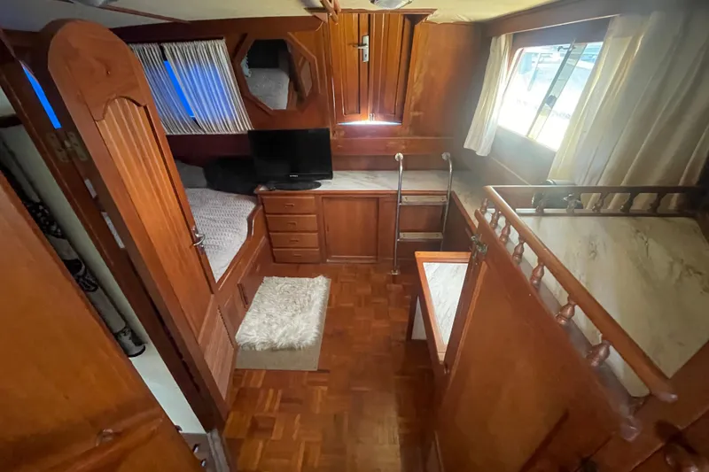 Slide: The Image of 1979 Golden Star Aft Cabin interior with wood paneling, cozy bed, and TV. - 22