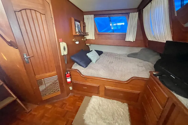 Slide: The Image of 1979 Golden Star Aft Cabin interior with cozy bed, wooden furnishings, and nautical decor. - 23
