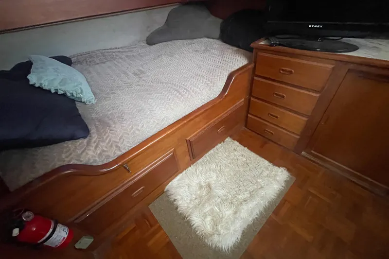 Slide: The Image of Cozy 1979 Golden Star Aft Cabin interior with bed, wooden drawers, and soft rug. - 25