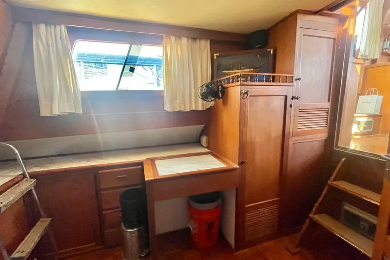 Slide: The Image of 1979 Golden Star Aft Cabin interior with wooden cabinetry and window. - 28