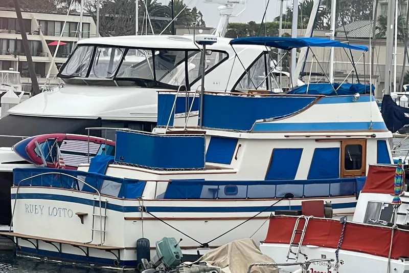Slide: The Image of 1979 Golden Star Aft Cabin boat with blue accents docked in a marina. - 29