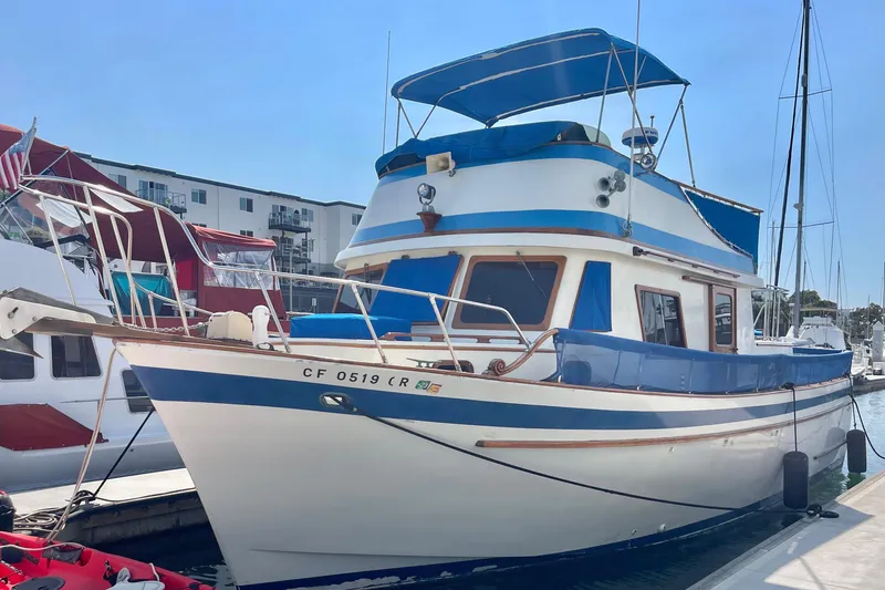 Slide: The Image of 1979 Golden Star Aft Cabin boat docked at marina, featuring blue and white design. - 4