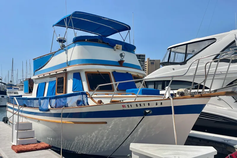 Slide: The Image of 1979 Golden Star Aft Cabin boat docked at marina, featuring blue and white design. - 5
