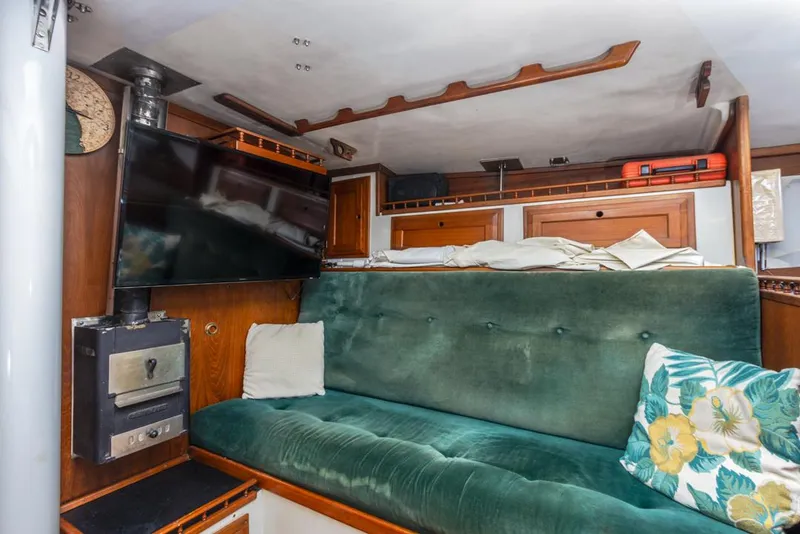 Slide: The Image of Interior of 1972 Columbia 43 Custom yacht with green sofa, TV, and wood accents. - 13