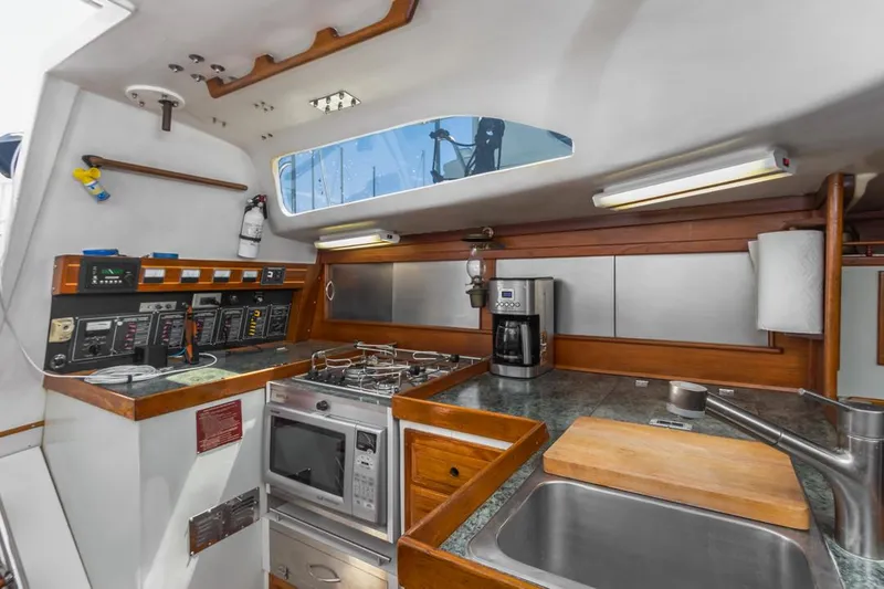 Slide: The Image of 1972 Columbia 43 Custom yacht kitchen with modern appliances and wood accents. - 17