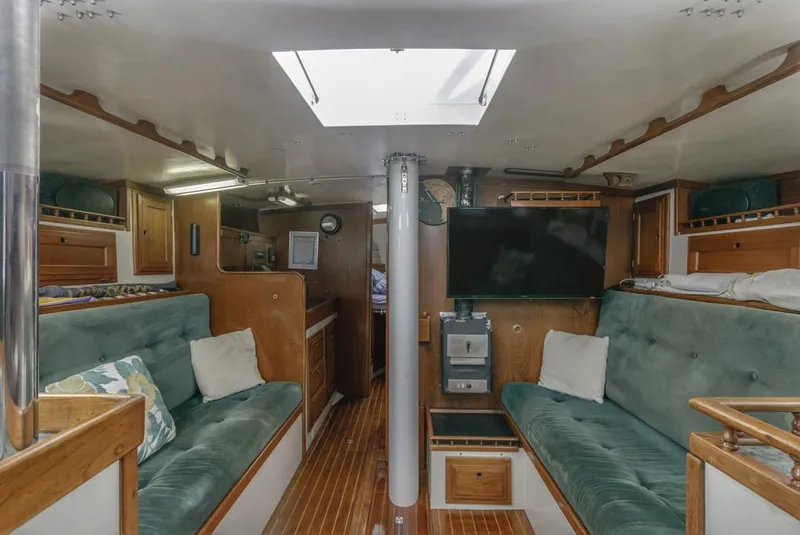 Slide: The Image of 1972 Columbia 43 Custom sailboat docked in a marina, featuring a spacious cockpit and steering wheel. - 2