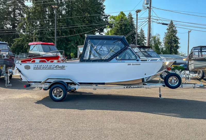 Slide: The Image of 2024 Hewescraft 200 Sportsman boat on trailer, parked outdoors. - 2