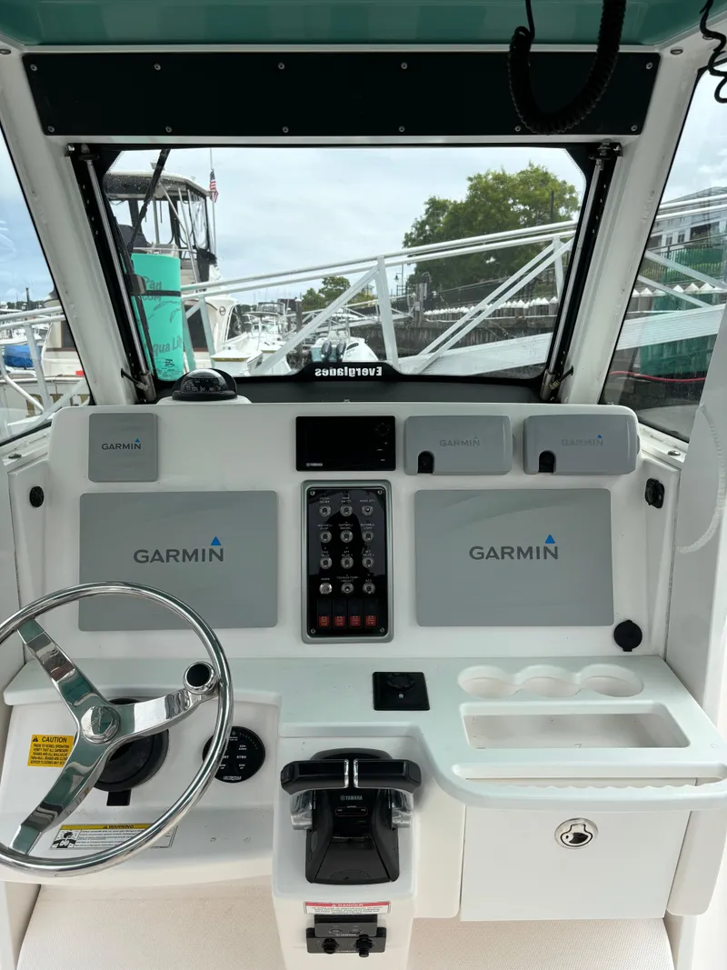 Slide: The Image of 2014 Everglades 295 boat dashboard with Garmin navigation system and steering wheel. - 11