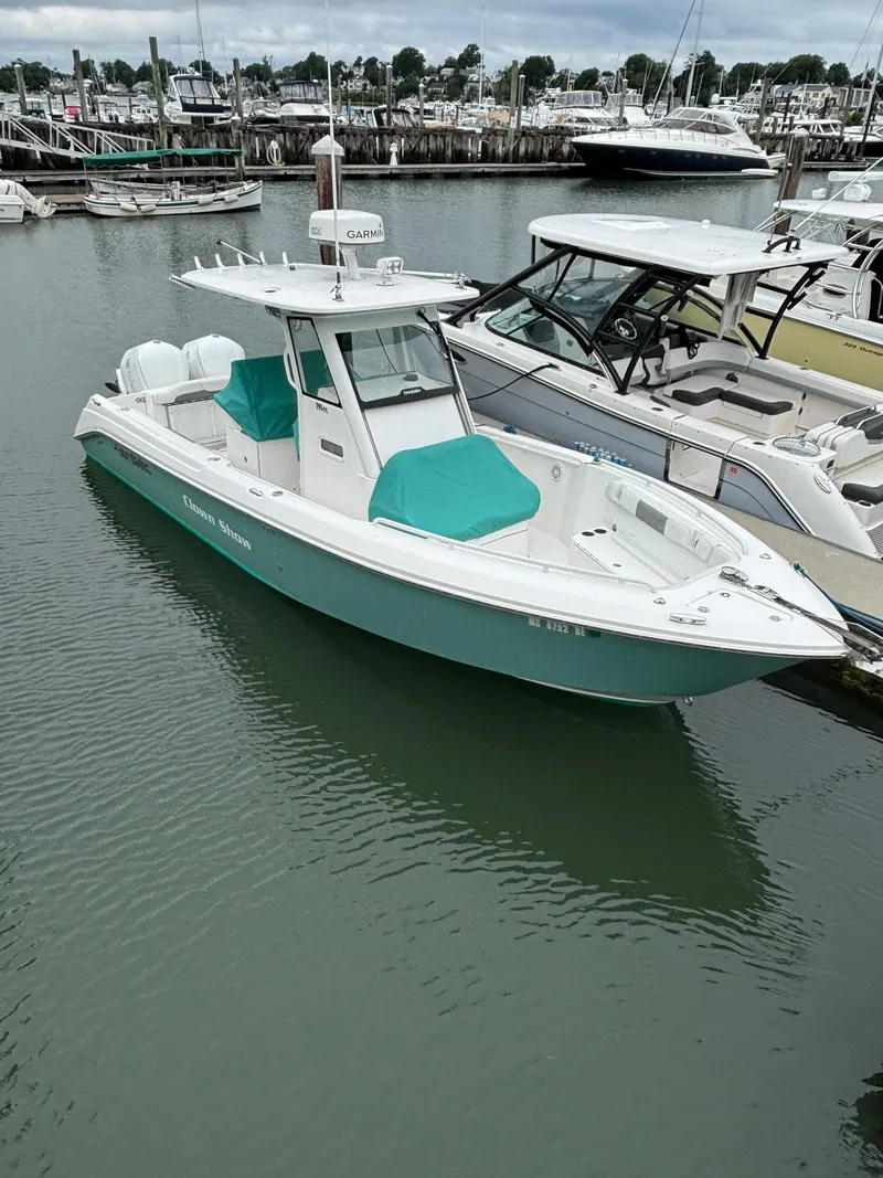 Slide: The Image of 2014 Everglades 295 boat docked in marina, featuring teal accents and sleek design. - 6