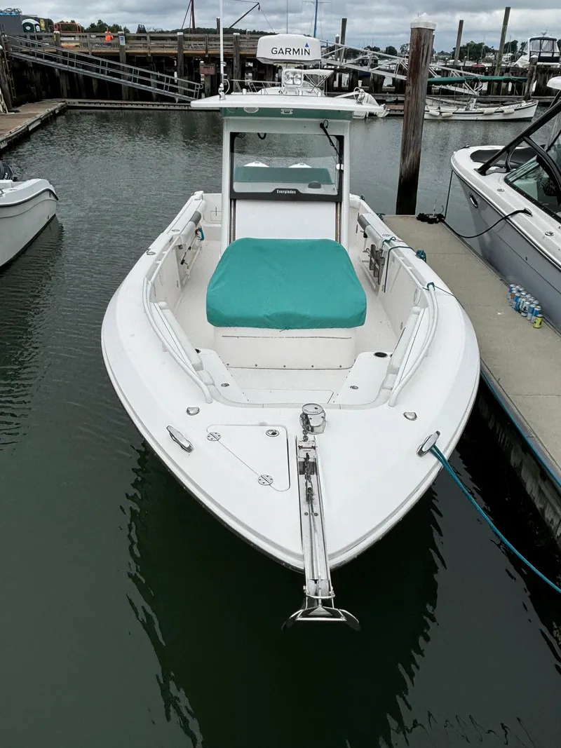 Slide: The Image of 2014 Everglades 295 boat docked in marina, featuring teal seating and Garmin equipment. - 7