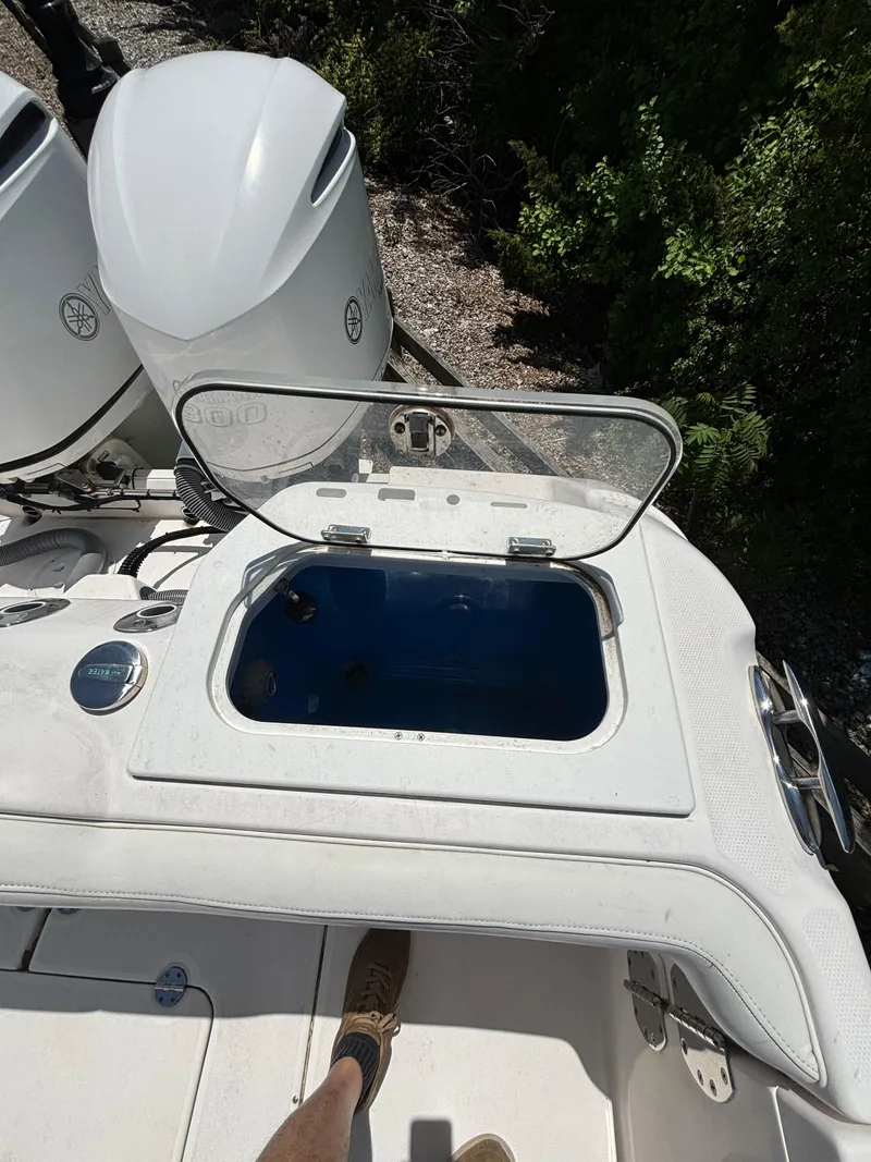 Slide: The Image of Open hatch on 2014 Everglades 295 boat with visible engine and greenery. - 9