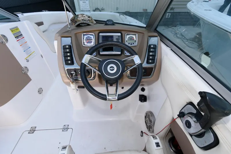 Slide: The Image of 2013 Chaparral 224 Sunesta boat dashboard with steering wheel and controls. - 6