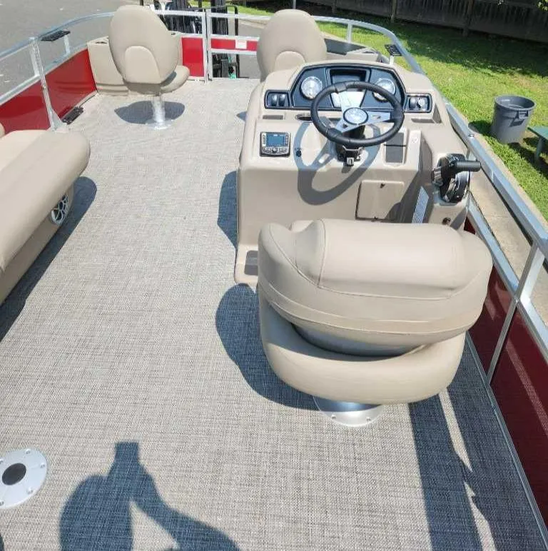 Slide: The Image of 2024 Ranger Reata 200F boat interior with beige seating and modern dashboard. - 2