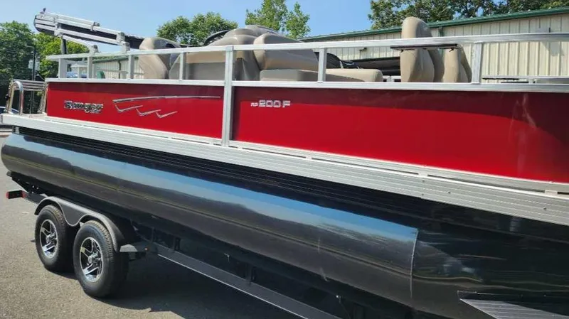 Slide: The Image of 2024 Ranger Reata 200F pontoon boat with red and black exterior on a trailer. - 5