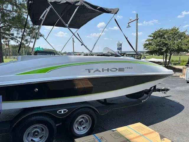 Slide: The Image of 2024 Tahoe 1950 boat on trailer, parked outdoors under clear blue sky. - 0