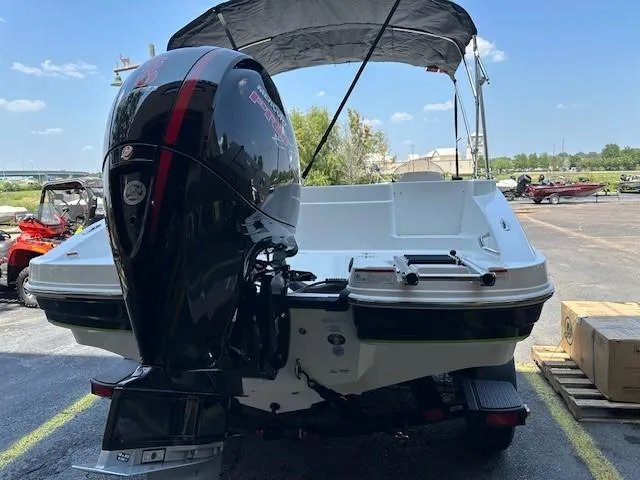 Slide: The Image of 2024 Tahoe 1950 boat with outboard motor and canopy in a parking lot. - 1