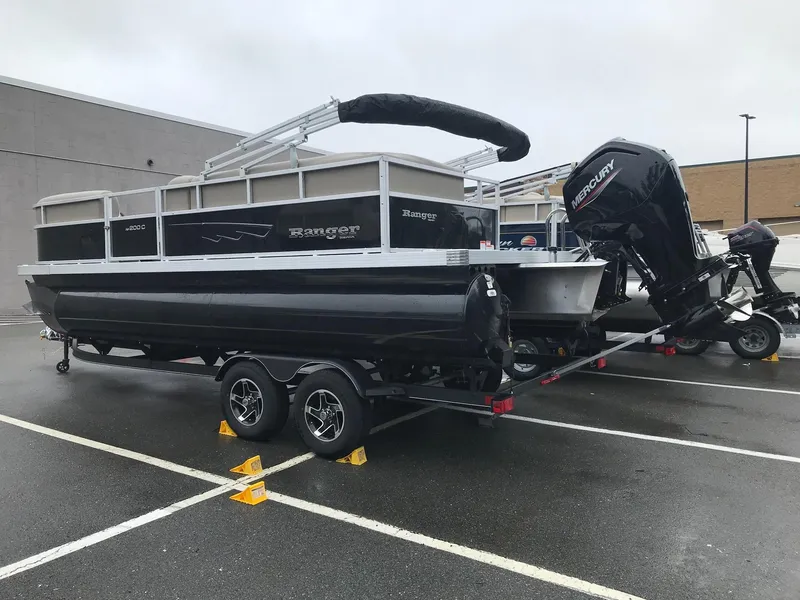 Slide: The Image of 2024 Ranger Reata 200C pontoon boat on trailer in parking lot. - 3