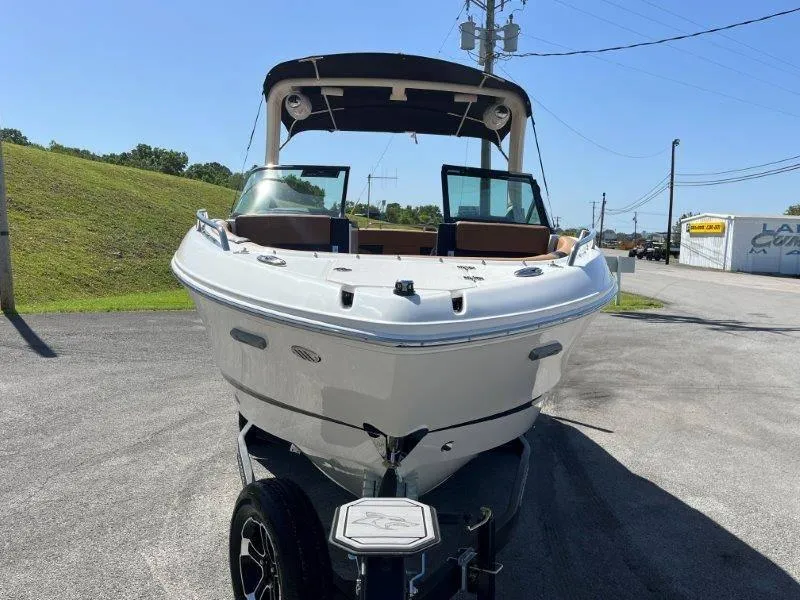 Slide: The Image of 2024 Chaparral 267 SSX boat on trailer, parked outdoors on a sunny day. - 14