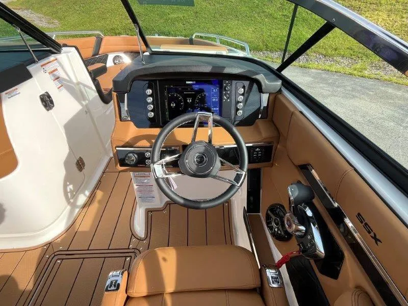Slide: The Image of 2024 Chaparral 267 SSX boat cockpit with modern steering and dashboard controls. - 27
