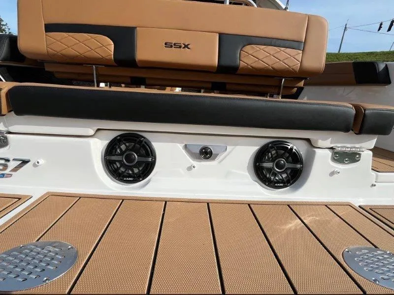 Slide: The Image of 2024 Chaparral 267 SSX boat with tan seating and integrated speakers. - 32