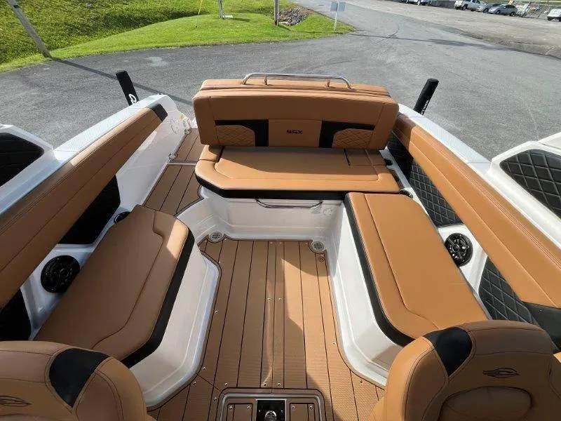 Slide: The Image of 2024 Chaparral 267 SSX boat interior with tan leather seating and wood flooring. - 36