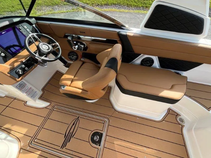 Slide: The Image of 2024 Chaparral 267 SSX boat interior with tan leather seats and modern dashboard. - 37