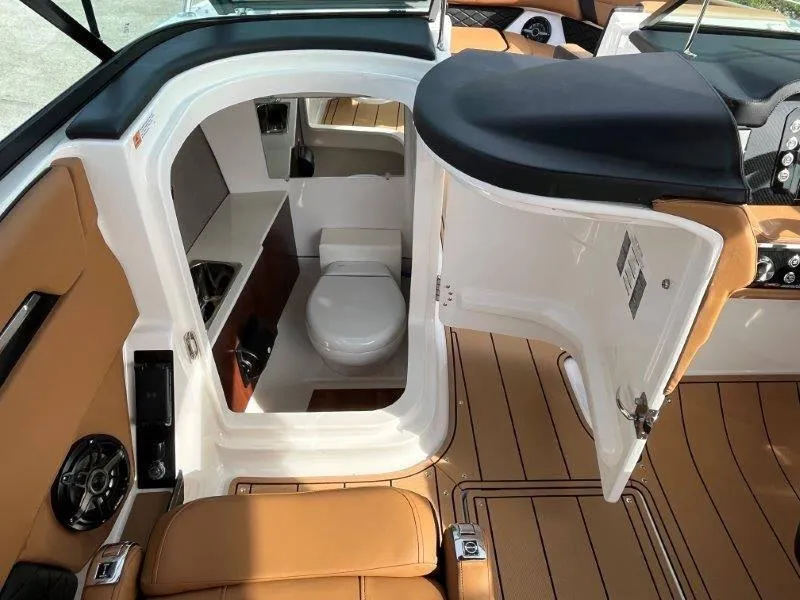 Slide: The Image of 2024 Chaparral 267 SSX boat interior with compact bathroom and modern amenities. - 41