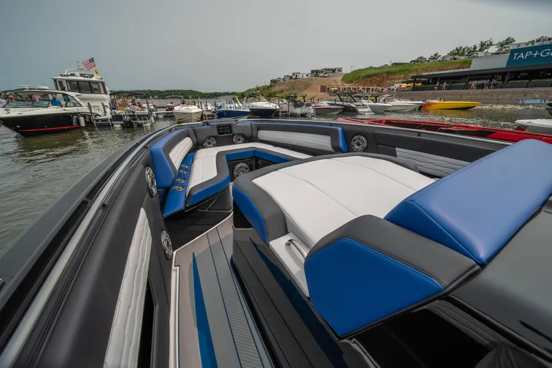 Slide: The Image of 2025 Cigarette 42 Auroris luxury boat interior with blue and white seating, docked at marina. - 42