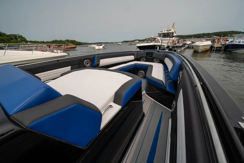 Slide: The Image of 2025 Cigarette 42 Auroris luxury boat with blue and white seating, docked in a marina. - 44