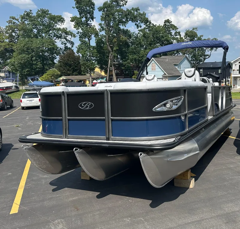 Slide: The Image of 2025 Bentley Pontoons Elite 223 Swingback Dual Capt. on display in a parking lot. - 1