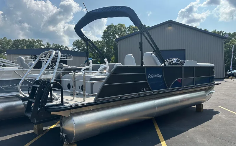 Slide: The Image of 2025 Bentley Pontoons Elite 223 Swingback Dual Capt. in marina setting, sunny day. - 3