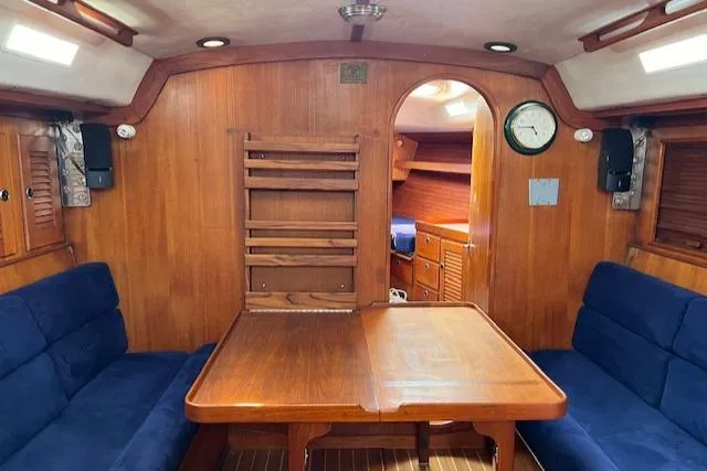 Slide: The Image of Interior of 1994 J Boats J 44 sailboat with wooden table and blue seating. - 13