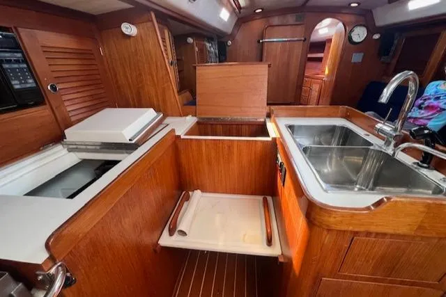 Slide: The Image of Interior of 1994 J Boats J 44 sailboat featuring a wooden galley with sink and storage. - 16