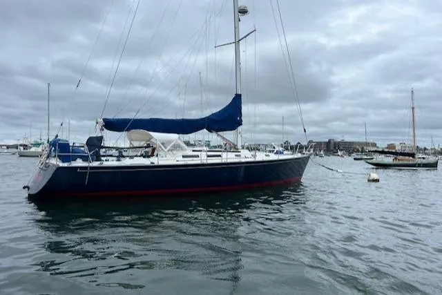Slide: The Image of 1994 J Boats J 44 sailboat anchored in a harbor under cloudy skies. - 2