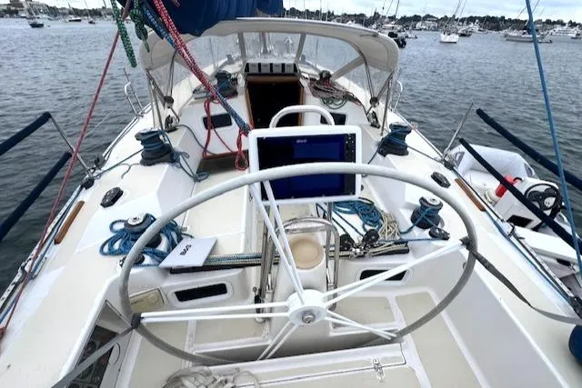 Slide: The Image of 1994 J Boats J 44 sailboat cockpit with steering wheel, ropes, and navigation equipment. - 5