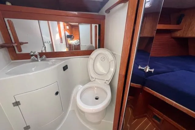 Slide: The Image of 1994 J Boats J 44 yacht bathroom with sink, toilet, and adjacent cabin. - 7
