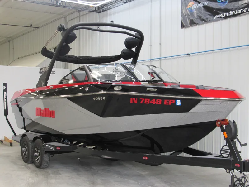 Slide: The Image of 2024 Malibu Wakesetter 23 LSV boat in showroom, red and black design. - 2