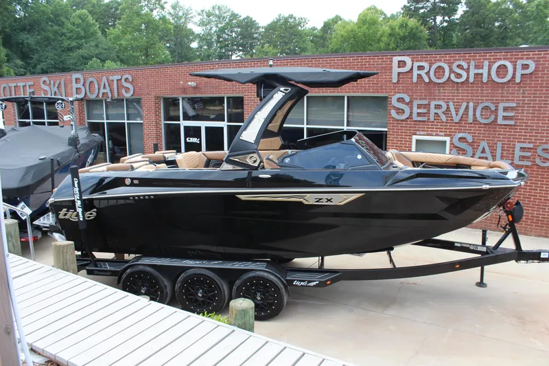 Slide: The Image of 2024 Tigé Ultré 23ZX boat displayed at a dealership, featuring sleek black design. - 3