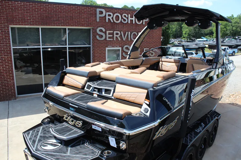 Slide: The Image of 2024 Tigé Ultré 23ZX boat with tan seating, parked outside a pro shop. - 5
