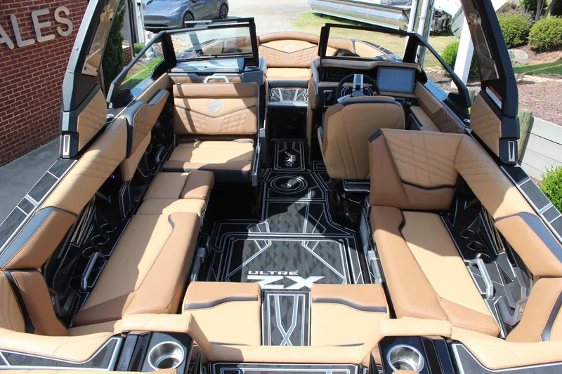 Slide: The Image of 2024 Tigé Ultré 23ZX boat interior with tan seating and modern dashboard. - 7