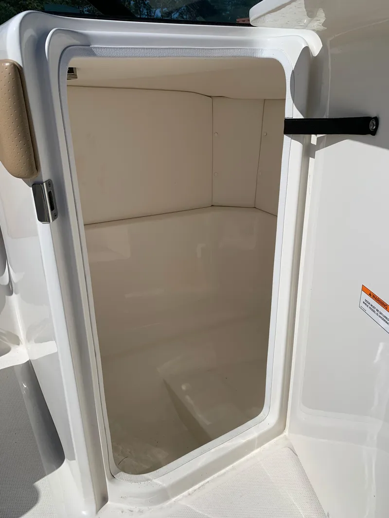 Slide: The Image of Storage compartment on a 2022 Sea Ray SPX 230 OB boat, open door view. - 10