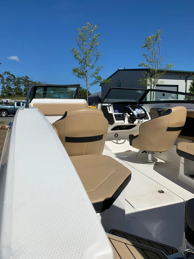 Slide: The Image of 2022 Sea Ray SPX 230 OB boat interior with tan seats and modern dashboard. - 3