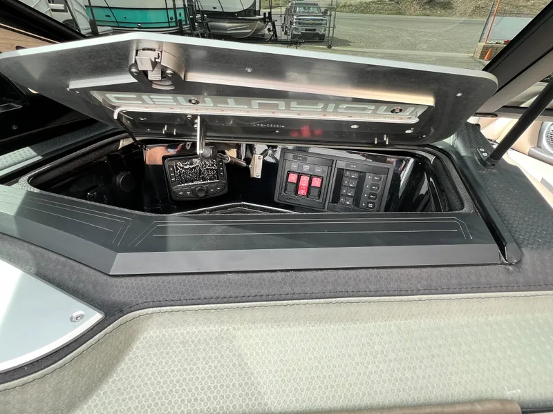 Slide: The Image of 2024 Centurion Ri230 boat storage compartment with control panel and switches. - 13